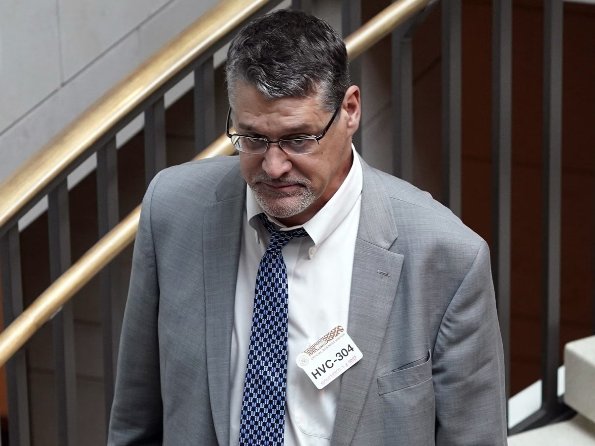 Glenn Simpson, co-founder of Fusion GPS, walking down a staircase at the U.S. Capitol wearing a congressional visitor badge