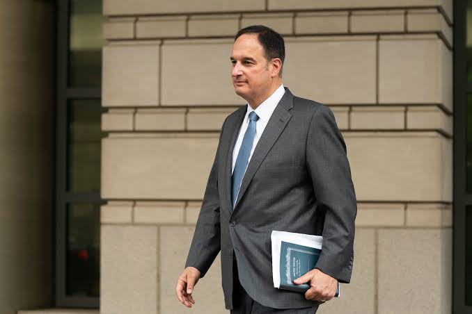 Michael Sussmann walking outside a federal courthouse in Washington, D.C., carrying documents
