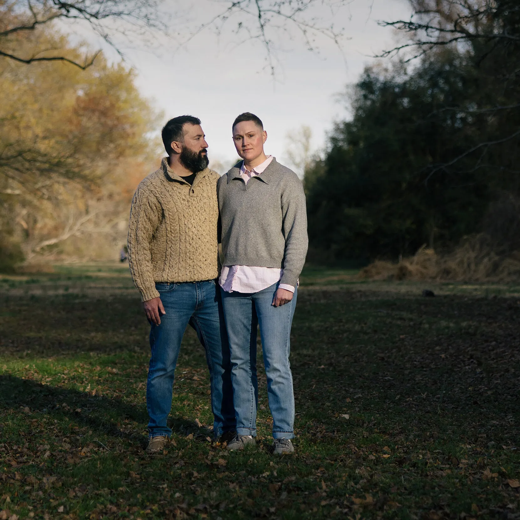 Shauni Kerkhoff, the former Capitol Police officer named in the Blaze report, standing beside a bearded man in a cable-knit sweater in a grassy clearing ringed by trees