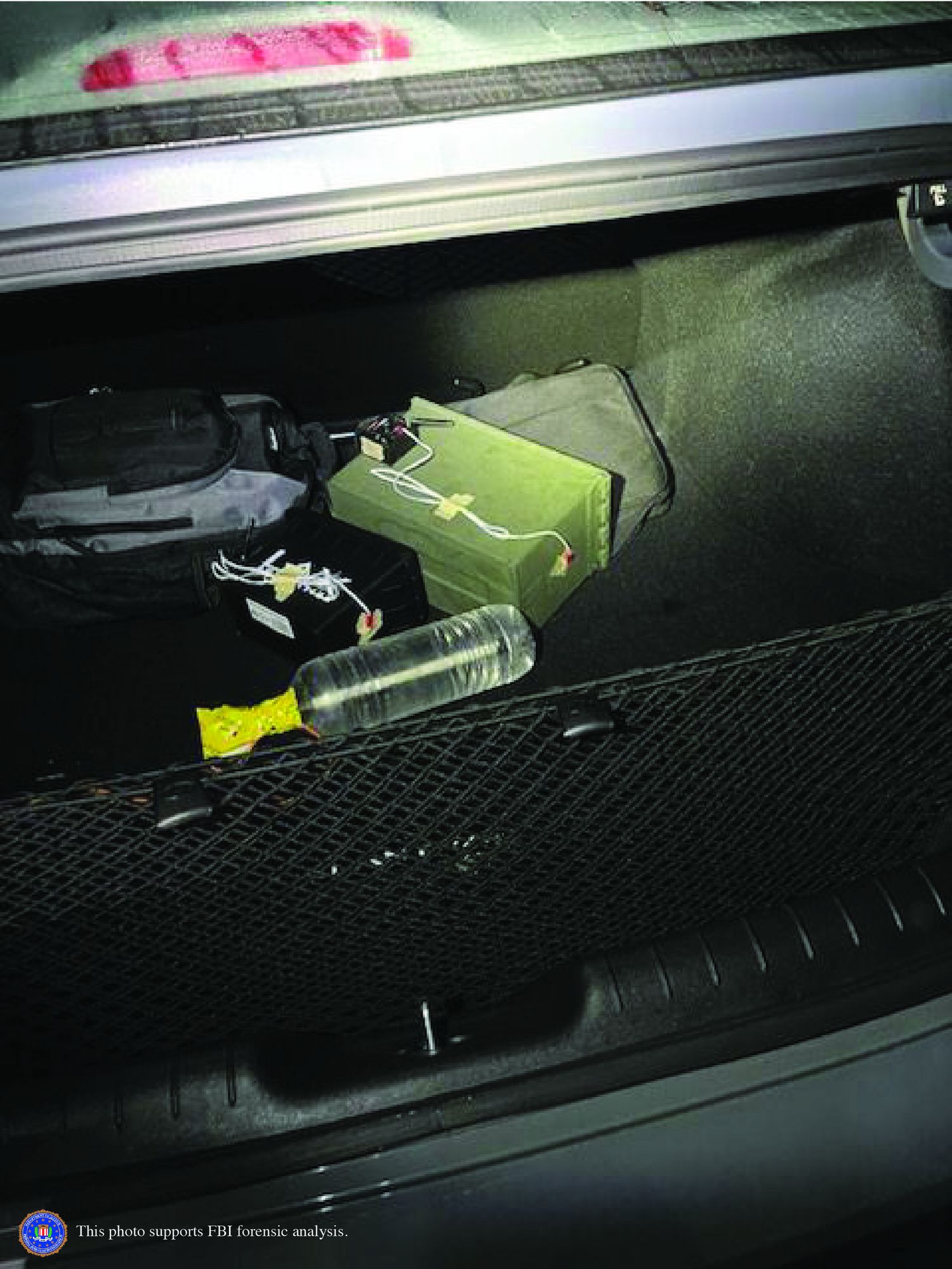 FBI forensic evidence photo of the inside of the trunk of Crooks's car, showing a green metal box wired with exposed cables next to a rigged plastic water bottle and a backpack