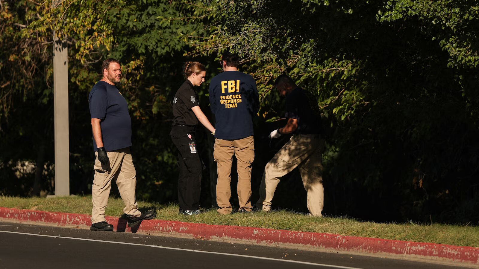 FBI Evidence Response Team members searching a wooded roadside area near Utah Valley University